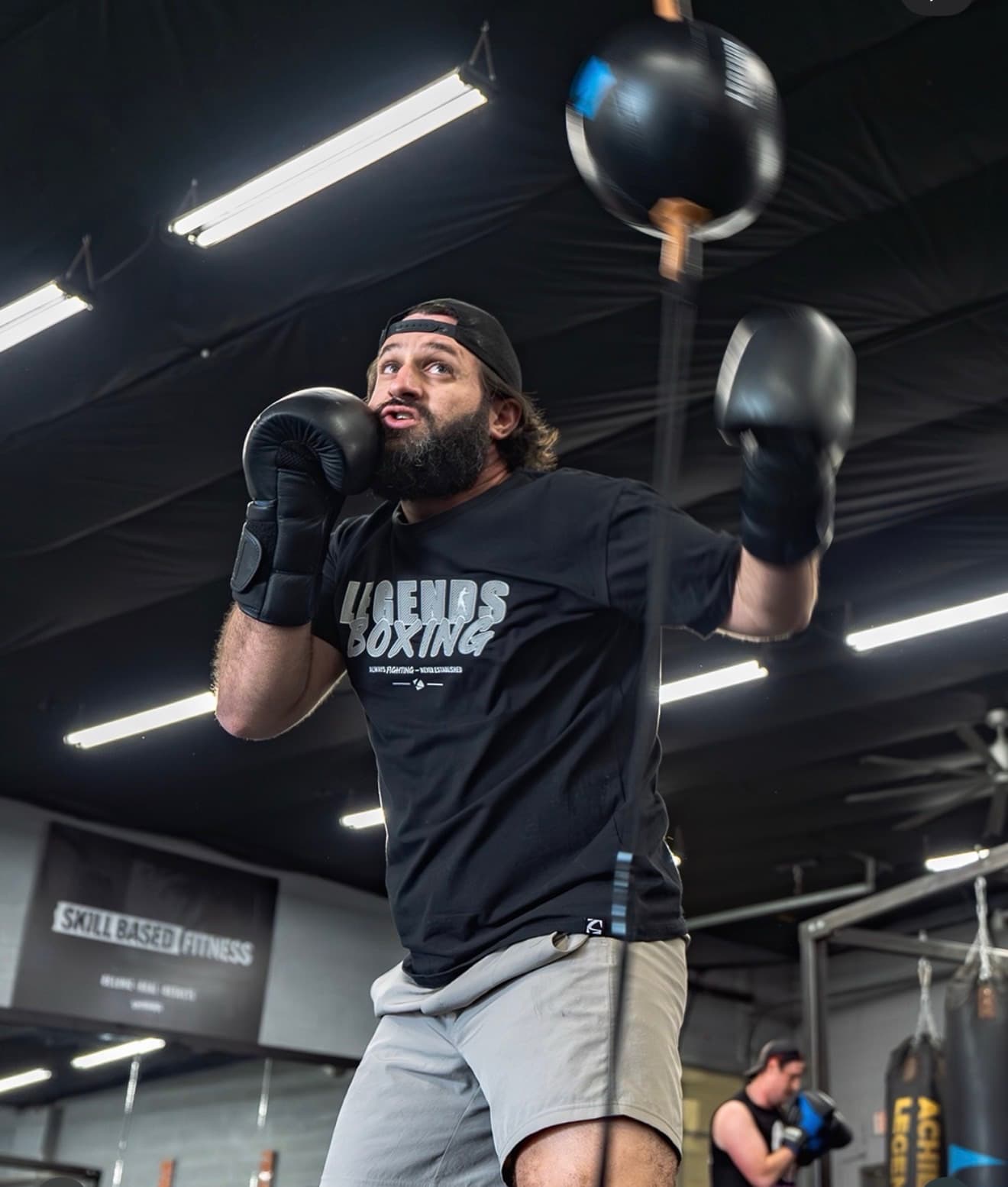 A member in a Legends Boxing tee working the double-end bag